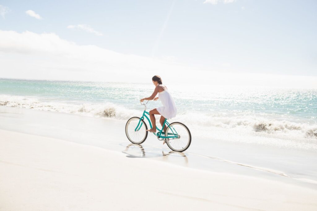 woman biking on the beach