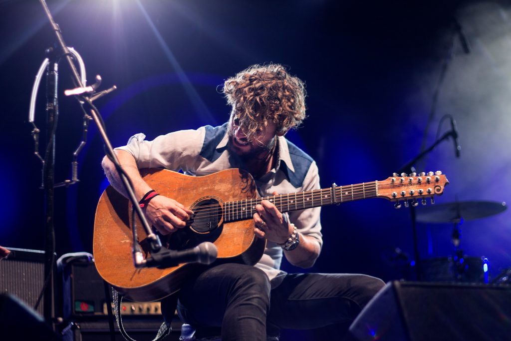 musician playing guitar on stage