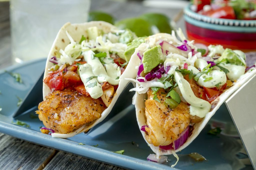 two fish tacos with coleslaw on a plate